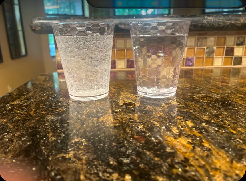 Two glasses of tap water from a Fresno home: cloudy before Nick's install, clear the next morning